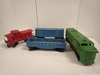 Four vintage Lionel train pieces displayed together on a white surface.