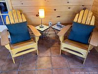 Overall setup showing two Adirondack chairs with cushions, two tile-top tables, table lamp, and ceramic bowl