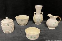 Five-piece set of Belleek porcelain from the Shamrock collection on black background