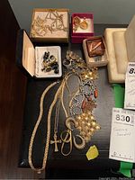 Overall view of necklaces, rings, earrings and cufflinks arranged on black surface