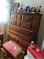 Full dresser showing five drawers, brass handles, and items on top not included in sale.