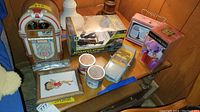 Overview of the collection including the toy jukebox, RC helicopter box, silver toy car, framed Betty Boop picture, and candles on a small table.