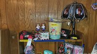 Photo showing the full lot including lamp, trash can, mug, glasses, license plates, and string lights on a shelf against wood panel wall