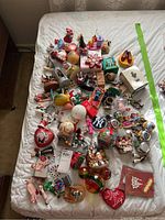 Wide shot of all ornaments spread out on a white bed including various character and novelty ornaments