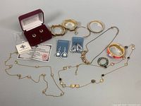 Full view of various jewelry including necklaces, bracelets, bangles, and earrings laid out on table