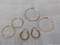 Photo showing all three pairs of 10K gold hoop earrings, two thin pairs (one round, one octagonal) and one thicker pair