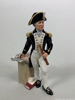 Full front view of Royal Doulton porcelain figurine showing naval captain with standing pose and details on clothing, pedestal, and telescope.