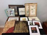 Overview of 12 prints and canvases arranged on table