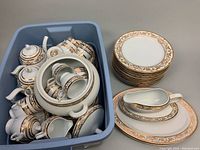 Bin with assorted tea/coffee service pieces, cups and saucers