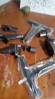 All Dyson vacuum accessories arranged on wooden surface, some wrapped in plastic