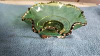 Green glass footed bowl with gold decorative trim and ornate gold-painted metal base shown from top angle.