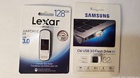 Photo showing Lexar 128GB JumpDrive S75 USB 3.0 flash drive in unopened packaging and Samsung 32GB USB 3.0 Flash Drive FIT in packaging.