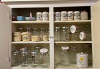 Three-shelf display of ceramic and glass storage jars