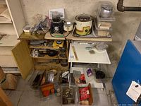 Overview of wooden cabinet shelf and white rolling table showing multiple jewelry equipment and supplies