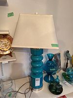 Front view showing white rectangular shade and stacked turquoise ceramic base