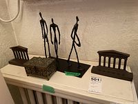 Overview of pair of bookends, abstract three-figure sculpture, and decorative box