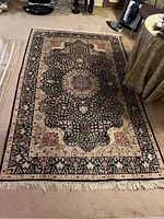 Full view of rug laid flat on floor showing overall pattern and condition