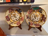 Two plates on wooden stands displayed on shelf