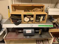 Bench polisher and three wooden accessory boxes on shelf