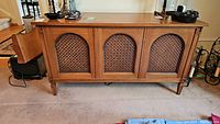 Front view of vintage Clairtone stereo console cabinet showing three arched speaker covers and wooden finish.