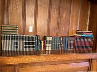 Full shelf view showing left-to-right assortment of books on wooden built-in shelf