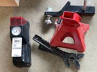 Overview photo showing the portable air compressor, red jack stand, and 2 inch hitch ball with mounting plate.
