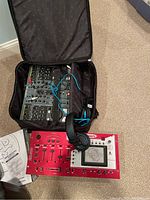 Numark mixer and Allen & Heath Xone:DX controller in an open black padded carrying case with headphones and cables