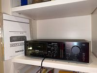 Black Nikko Stereo Cassette Deck ND-790 on shelf with owner's manual.