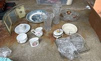 Photo showing beveled photo frame, glass bowls, pitchers, and bone china