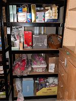 Full view of the metal shelving unit with various household items stored on shelves (not included in sale).