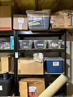 Full view of black metal shelving loaded with storage bins and boxes (not included).
