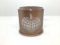 Front view of the brown metal tea candle holder with chevron pumpkin cutout design.