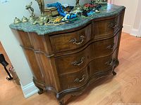 Front view of serpentine cabinet showing overall shape and drawer configuration