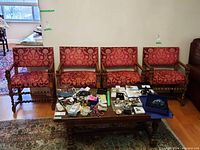 Four chairs in a row with coffee table and jewelry in foreground