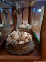 Bowl and tray arranged side by side filled with eggs, mirrored cabinet background
