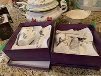 Photo showing two Adeline china snack sets boxed with mugs, plates, and spoons included.