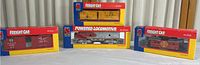 Four boxed Life-Like HO scale model train items: one powered locomotive and three freight cars in original boxes with visible wear.