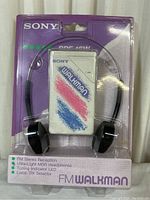 Front view of sealed Sony Walkman SRF-16W in purple packaging showing product and headphones