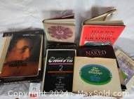 Photo showing a stack of hardcover books with visible titles related to erotic art.