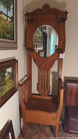 Full front view of oak hall seat and coat rack with storage bench, mirror and hooks