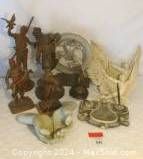 Six assorted statues including various styles and sizes mixed in metal, resin, and stone.