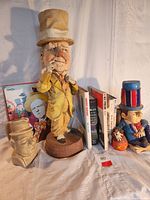 Image of collection showing W.C. Fields ceramic figurines, books, and LP records on a white draped surface.