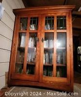 Front view of oak wood cabinet with glass doors closed