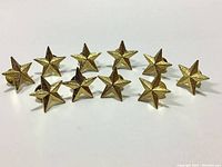 Photo of 10 gold star pin badges arranged in two rows.