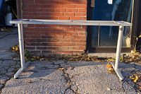 Full view of IKEA Galant metal table base frame outdoors on pavement showing overall condition and construction.