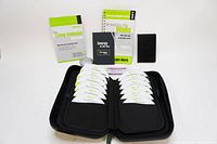 Full set of Living Kabbalah System items including 15 audio CDs arranged in an open black case, guide book, booklet, plain notebook, and affirmation magnets