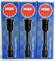 Front side of three NGK spark plug boots in original blue boxes showing the product and branding.