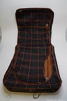 Open view of vintage foldable fabric suitcase showing plaid interior and expansion zipper, with a built-in hook for hanging suits