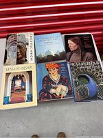 Top-down image showing all six art books arranged flat with visible covers and titles