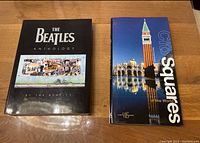 Front covers of The Beatles Anthology and City Squares hardcover books on a wooden surface
